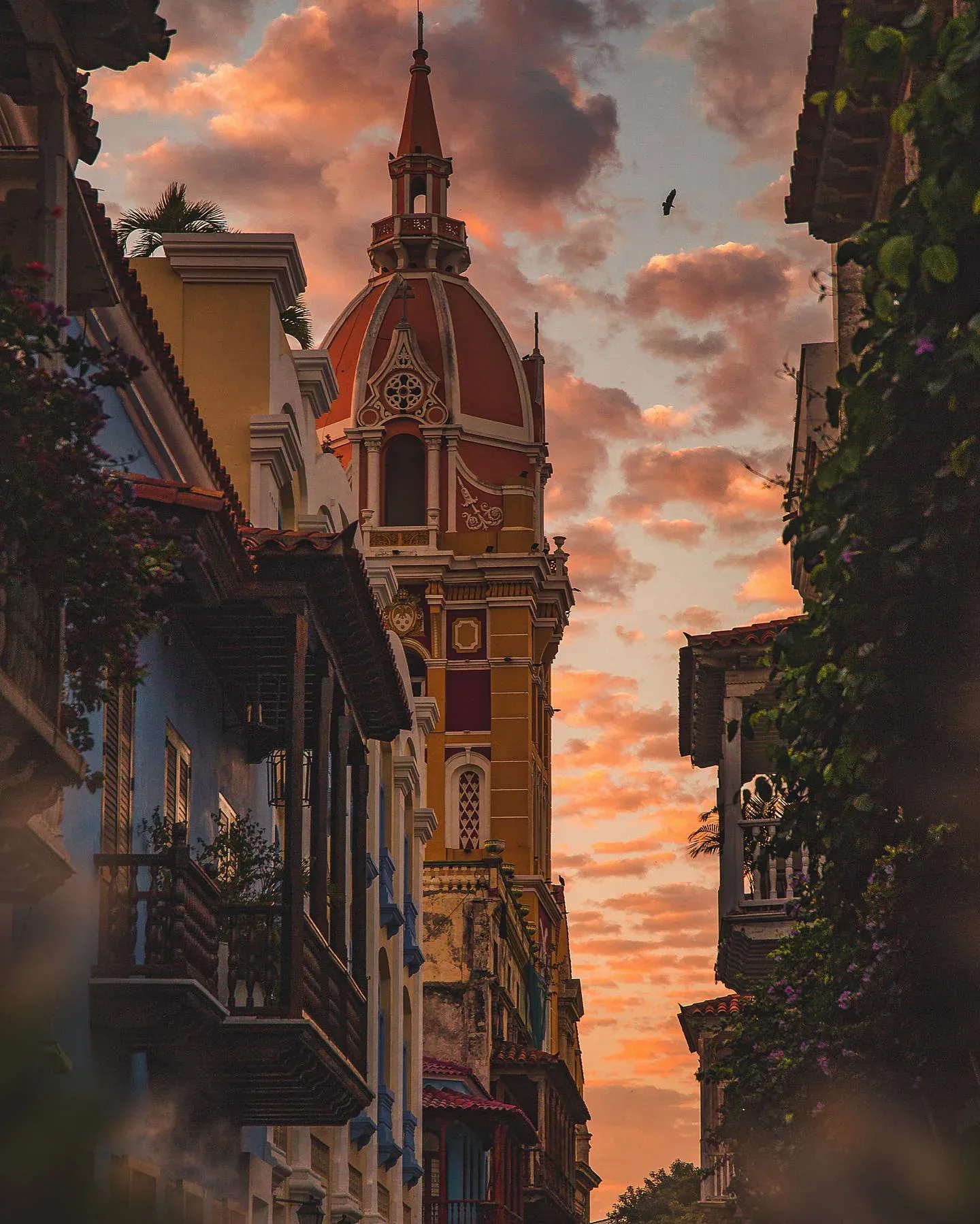 Church tower between colonial balconies at sunset