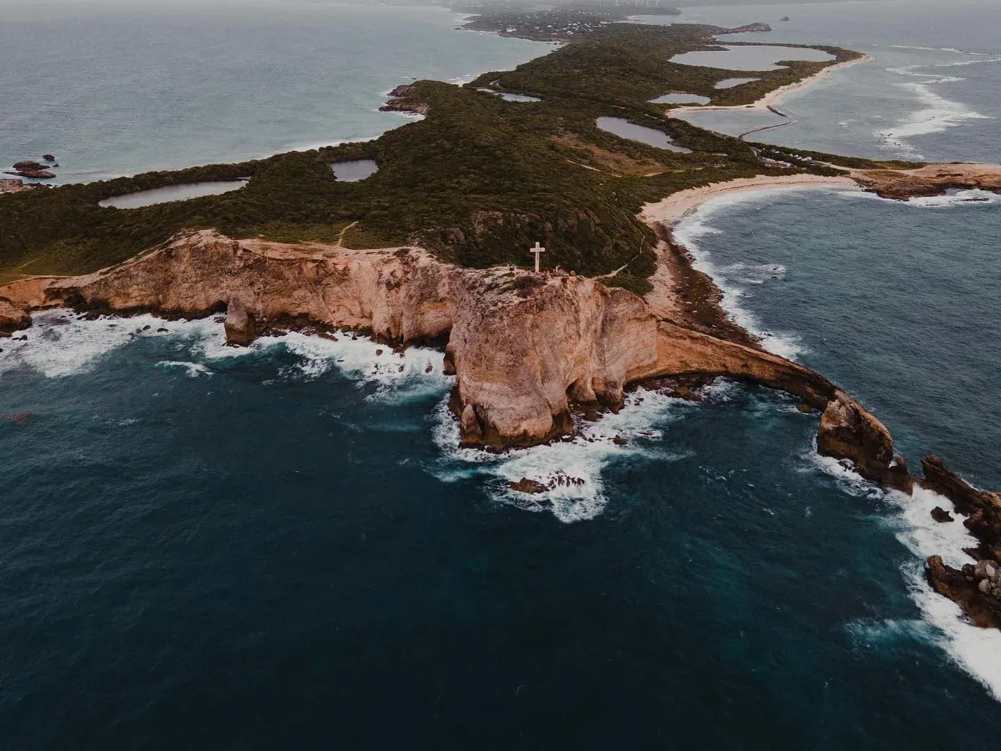 Aerial view of a rocky headland and surf