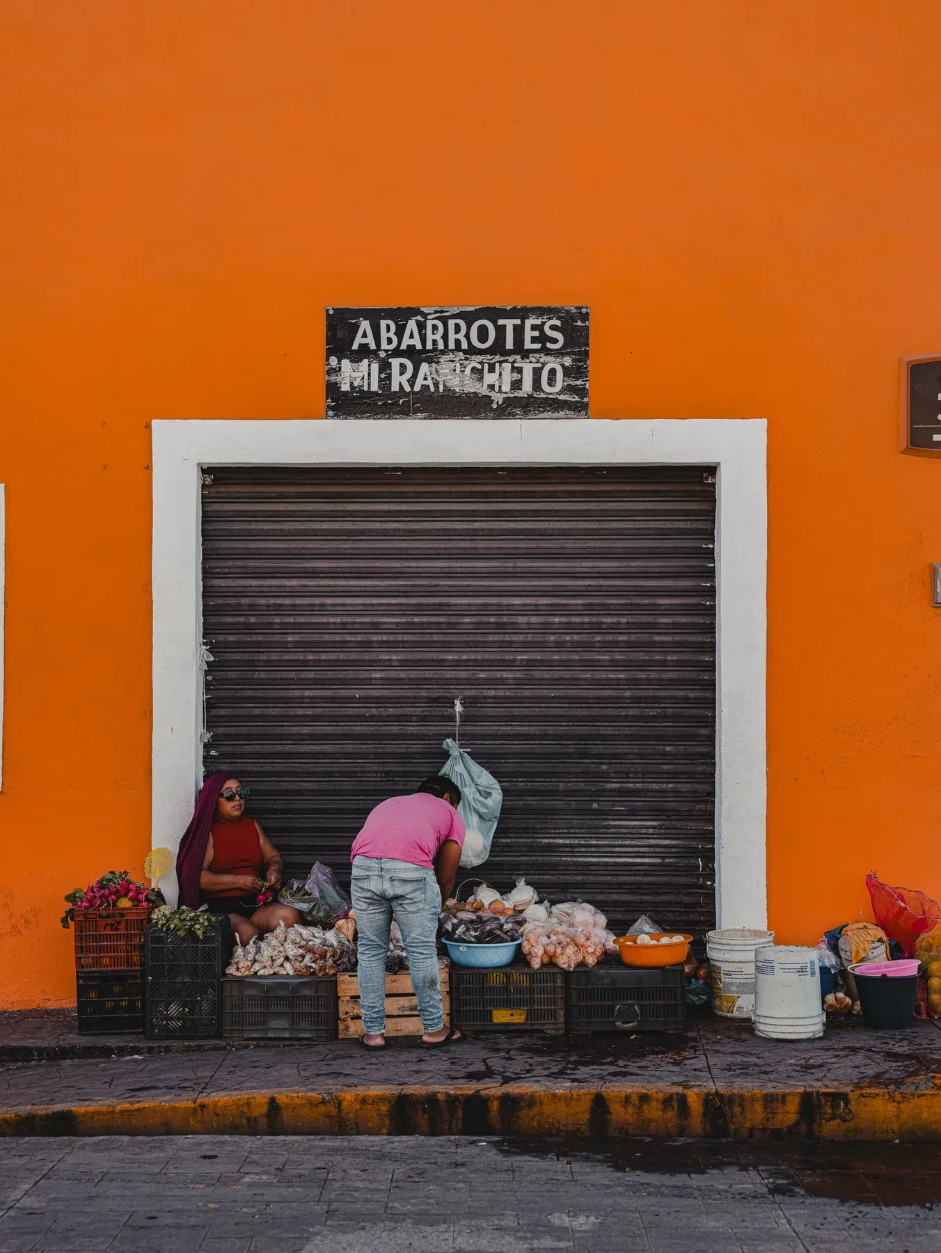 Street stall in front of an orange wall