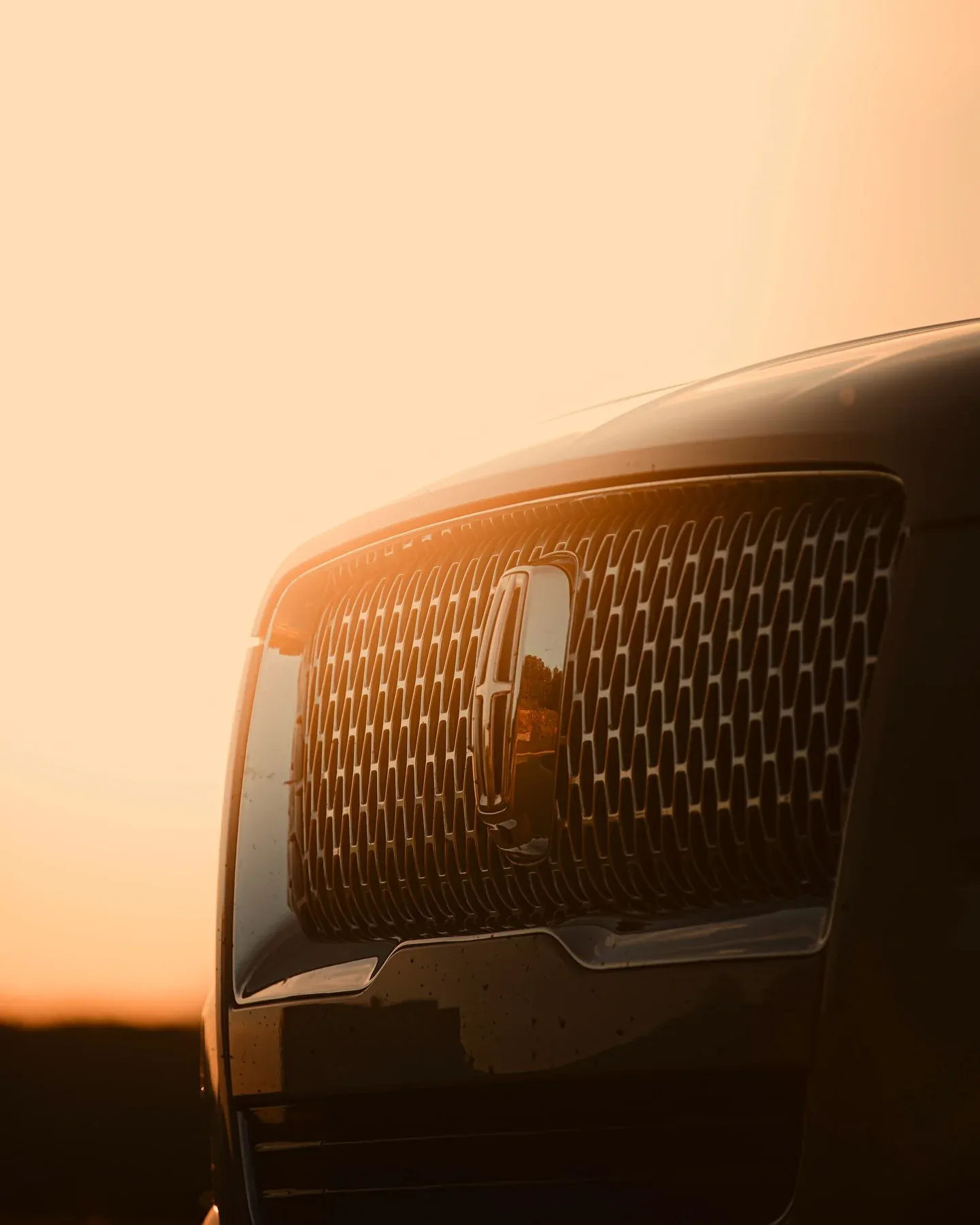 Front grille of an SUV glowing at sunset