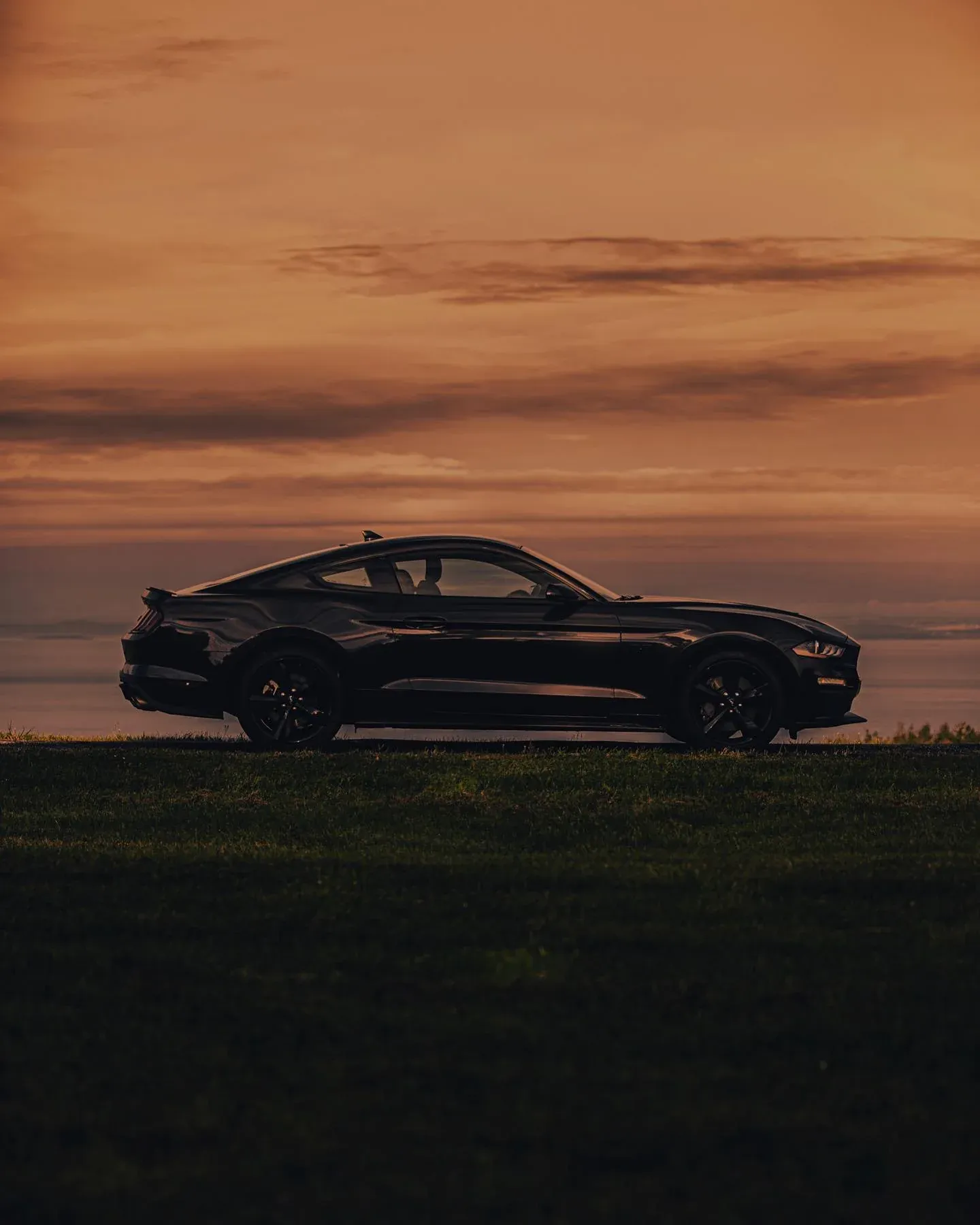 Sports car in profile against a sunset sky