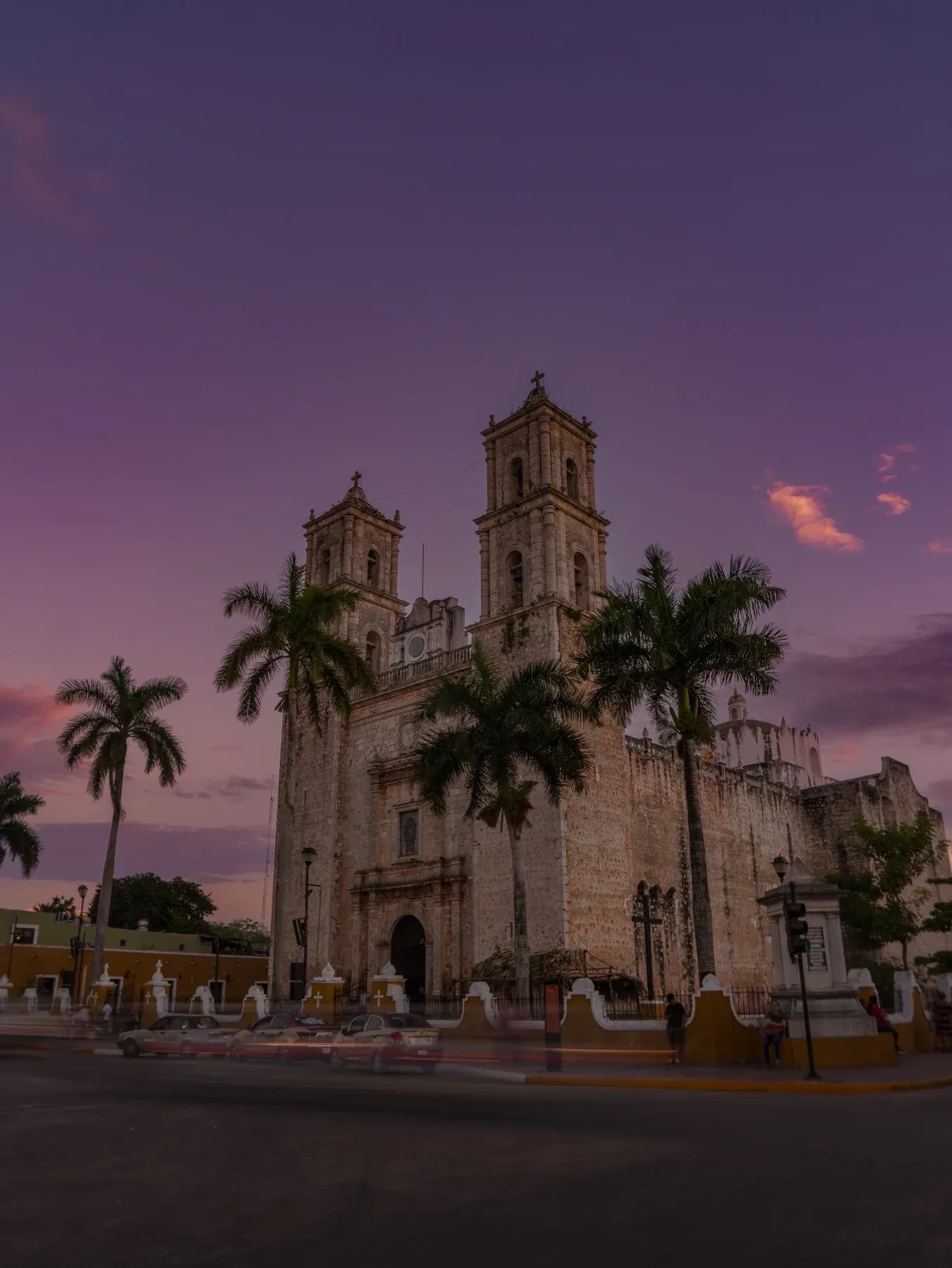 Twin-towered church and palms under a purple sky