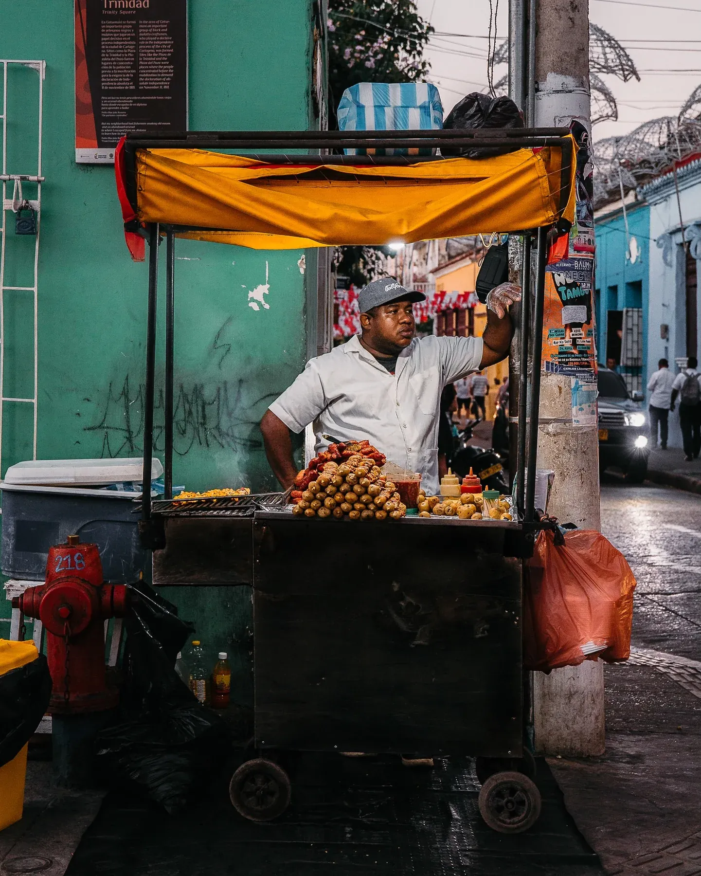Vendor at a fruit cart on a colourful street