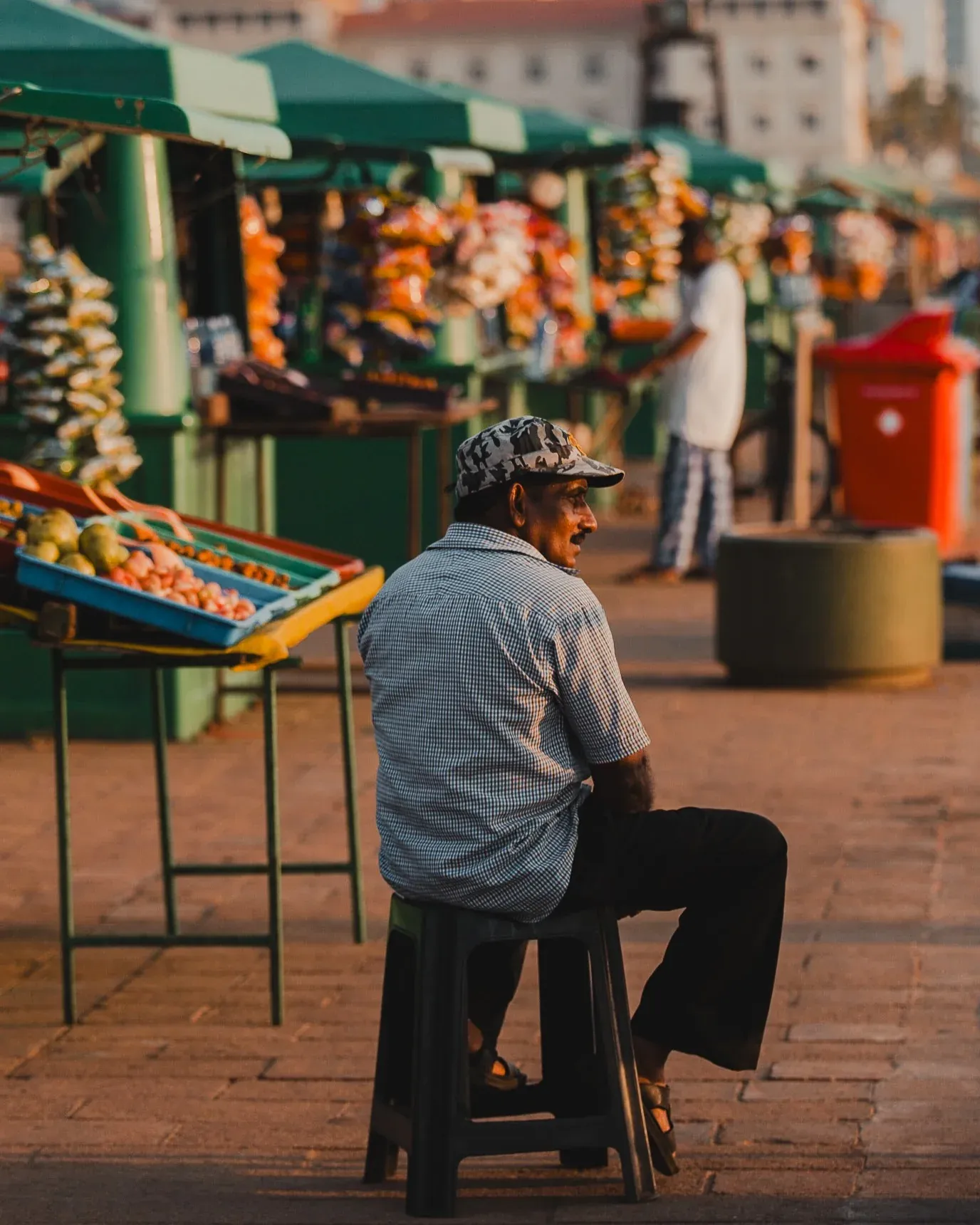Man sitting on a stool at a street market